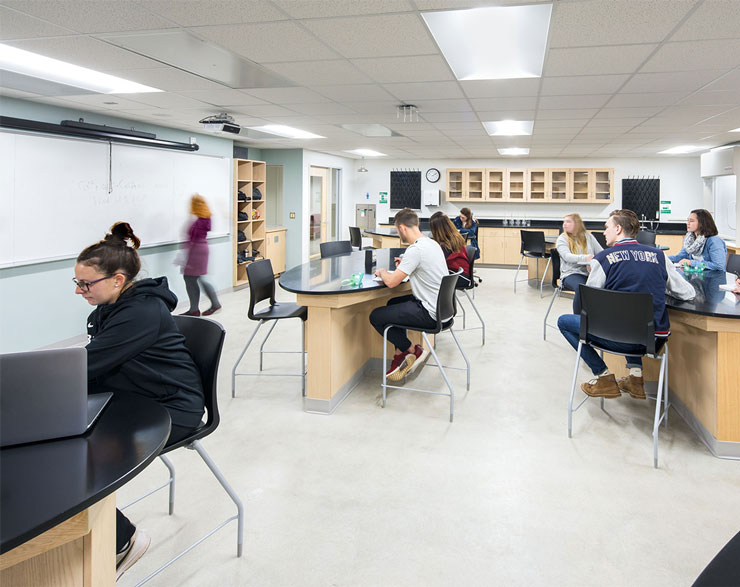 Students look toward the front of the lab at their teacher