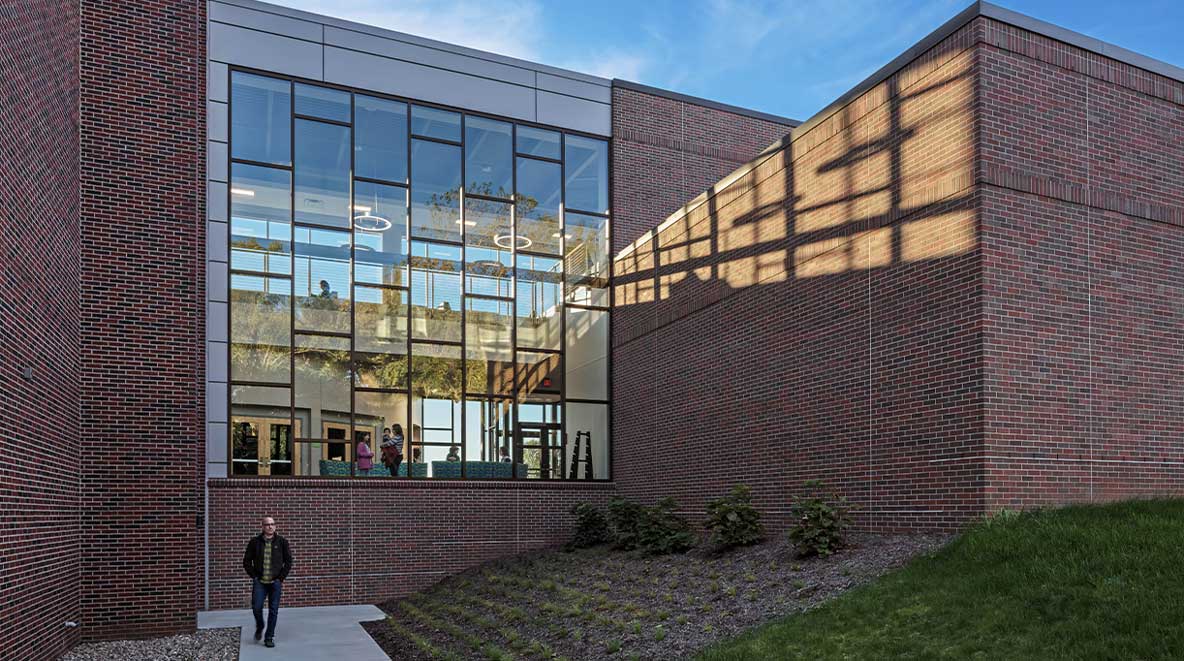 A glass wall of windows shows a sneak peak of what is inside the Grace College science complex