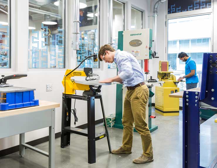 Student uses a saw while in the lab