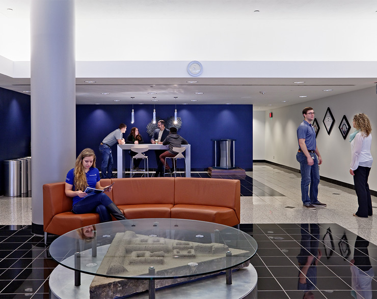 Groups of employees gather in different areas of the customer support center