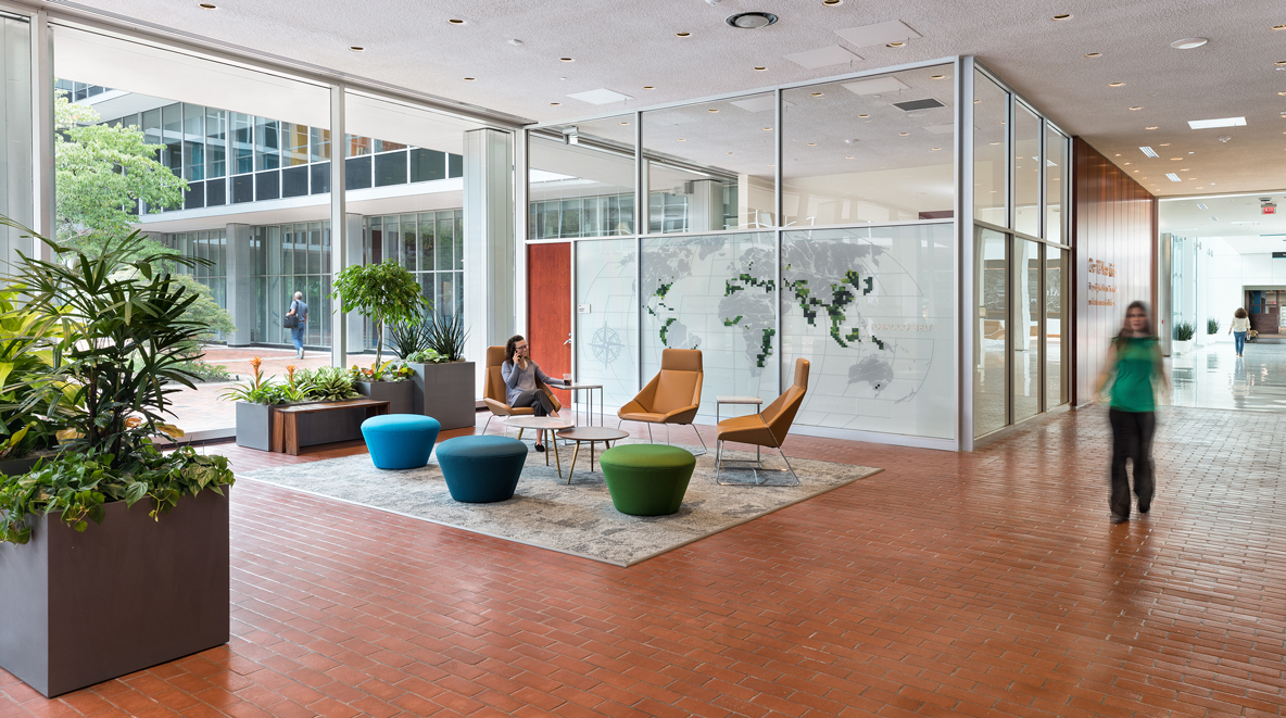 An employee waits in a seating area while another employee walks by