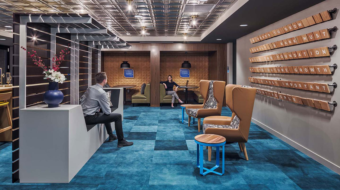 Two employees talk in a renovated space that used to be a bank vault