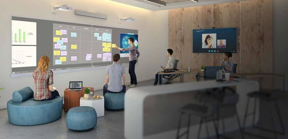 An in-person and remote team collaborate using technology on-screen