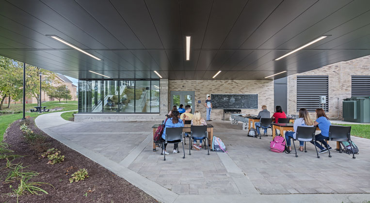 Students are seen in the outdoor classroom by the lake