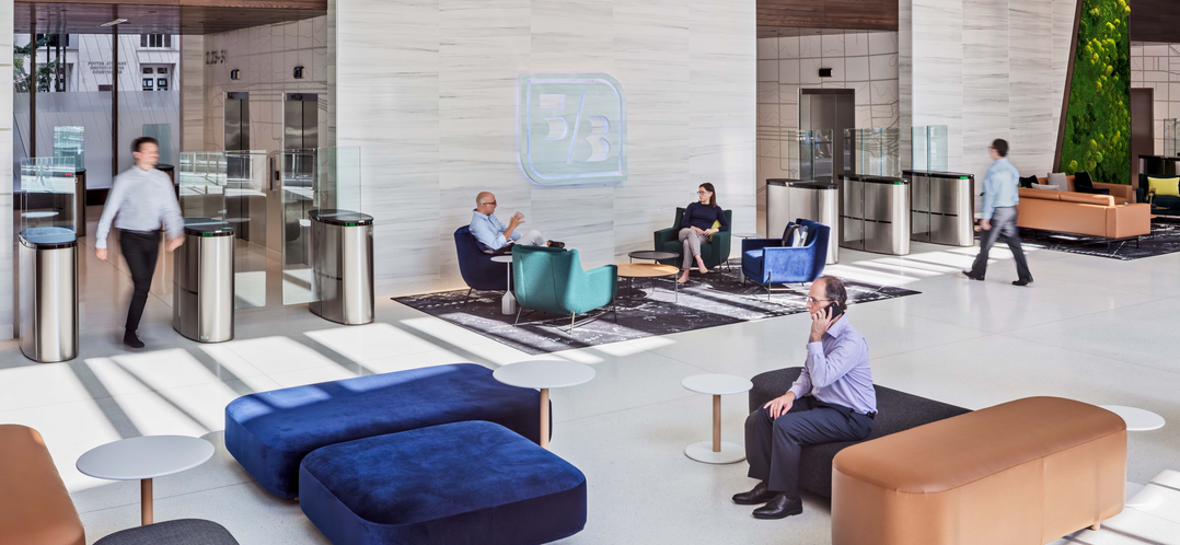 Fifth Third headquarters lobby with turnstiles, a green wall, and employees seated on lounge furniture.