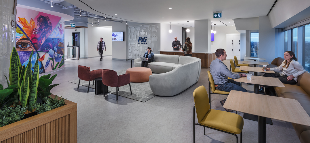 image of lounge space within an office area with booths, tables, chairs, and couches