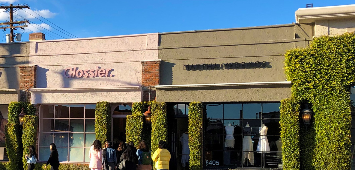 Shoppers wait in line to enter Glossier in California.