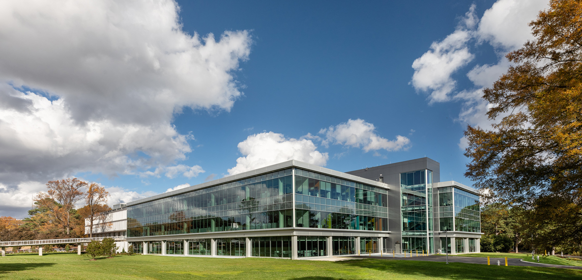 A building is shown with blue skies above it and prominent white clouds