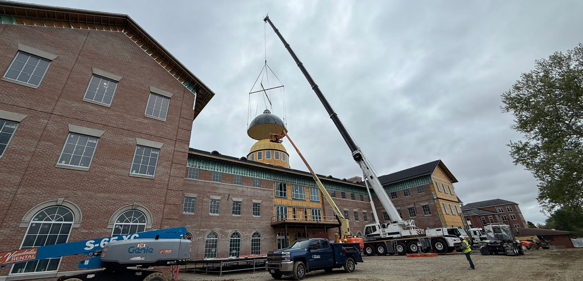 Construction crews place the 84-foot-tall dome on the Bolthouse Academic Center.