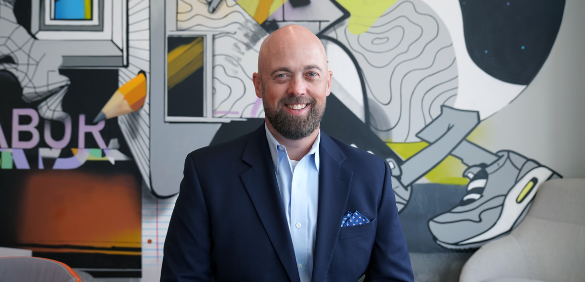 headshot of daniel lessing, new industrial market leader on BHDP mural background
