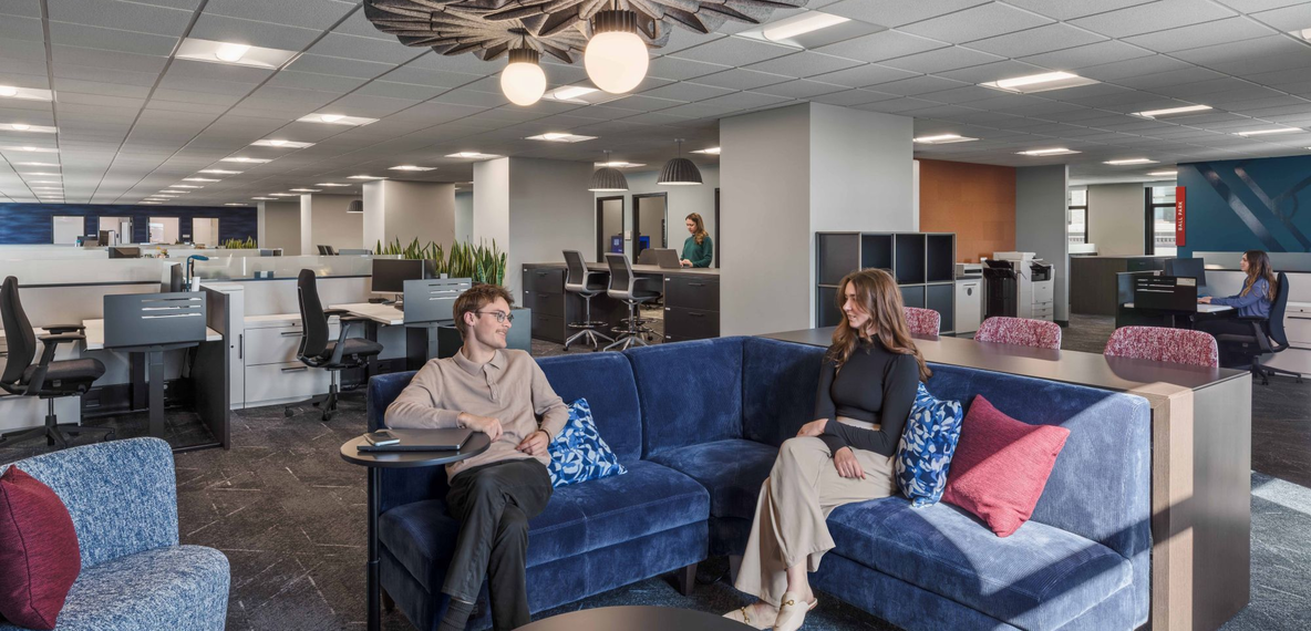 image of a lounge space within an office containing cubicle desks