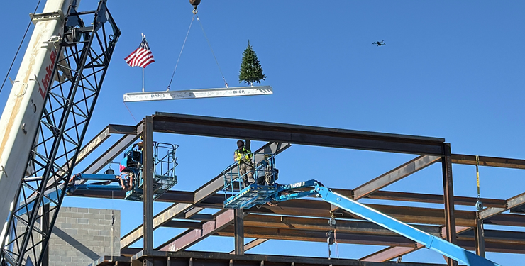 The final beam being placed on the three-story academic center.