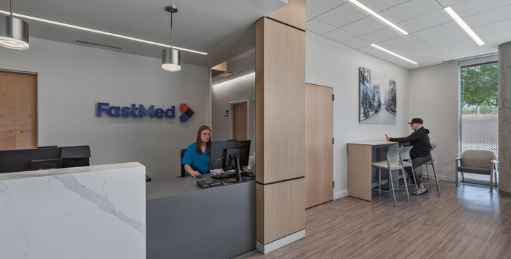 entrance to the new fastmed urgent care with a front desk on the left and a waiting area with tables on the right