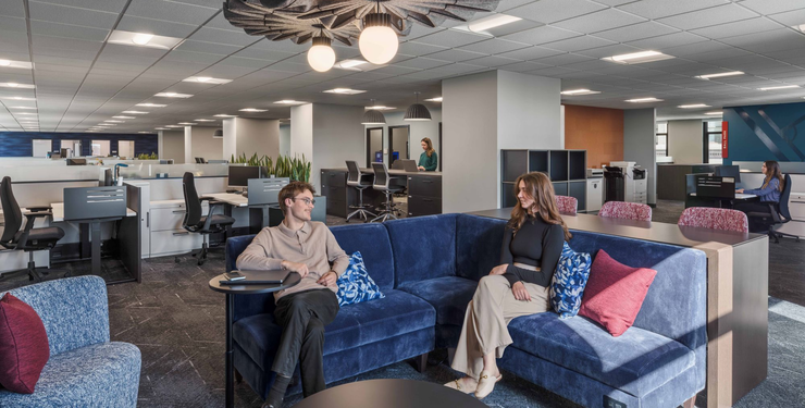 image of a lounge space in an office containing cubicle desks