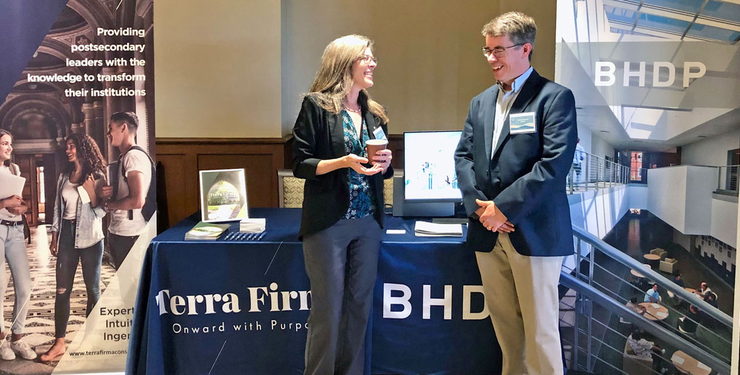 Two people stand in front of a booth for BHDP and Terra Firma