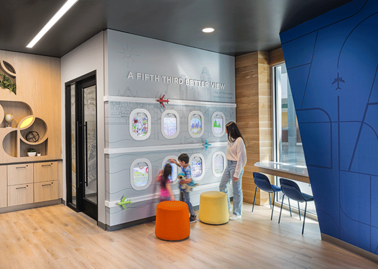 Mother and children enjoying interactive play at the CVG Fifth Third branch's kids corner.