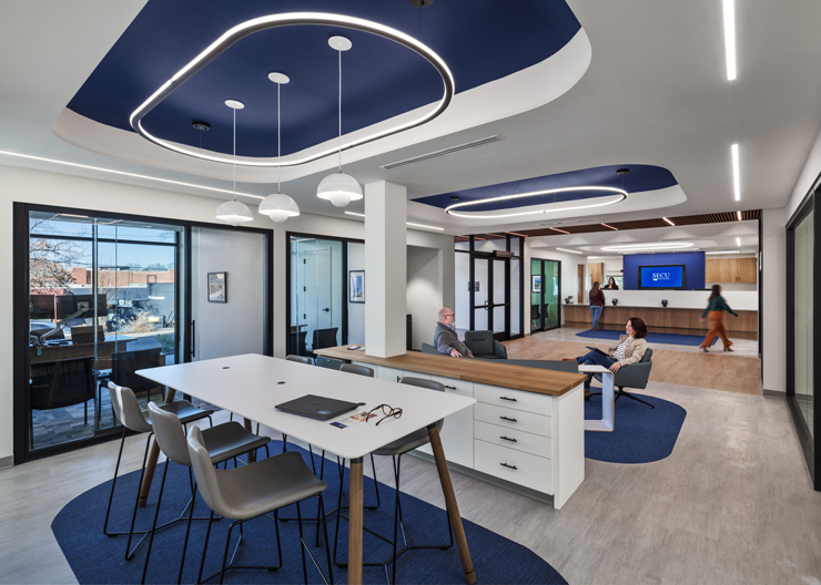 The open layout features comfy furniture in the middle with transparent offices on the perimeter