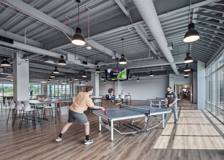 A game room where employees are playing ping pong