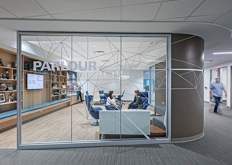 Employees collaborate behind a clear glass wall with privacy vinyl