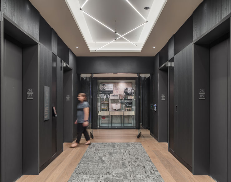 Elevator room wit light wood floors and black walls
