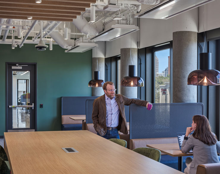 Man and women chatting in a open workspace room.