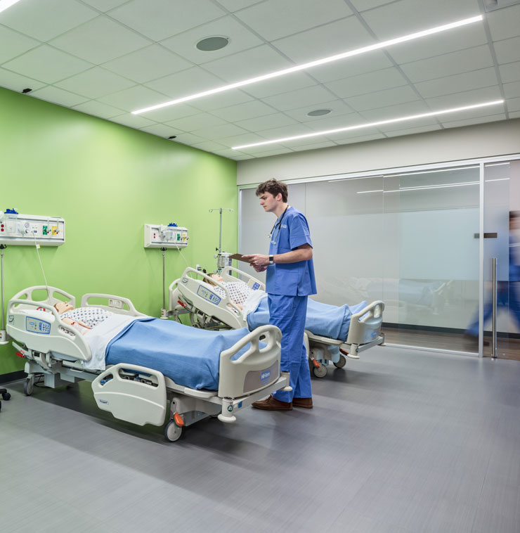 Nurse stands by hospital bed