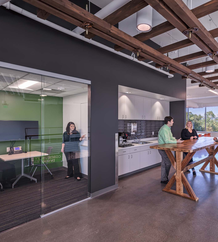 A huddle room is seen next to the small kitchen area