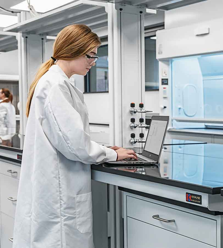 A female student works on her laptop inside a lab