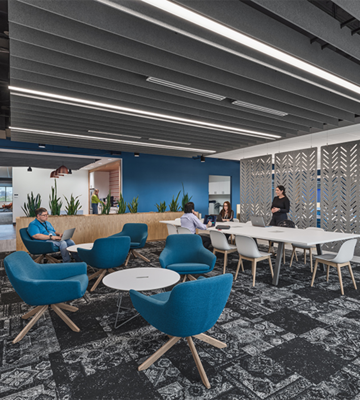 Tables throughout the office allow employees to have meetings, eat lunch, and do work away from a desk.