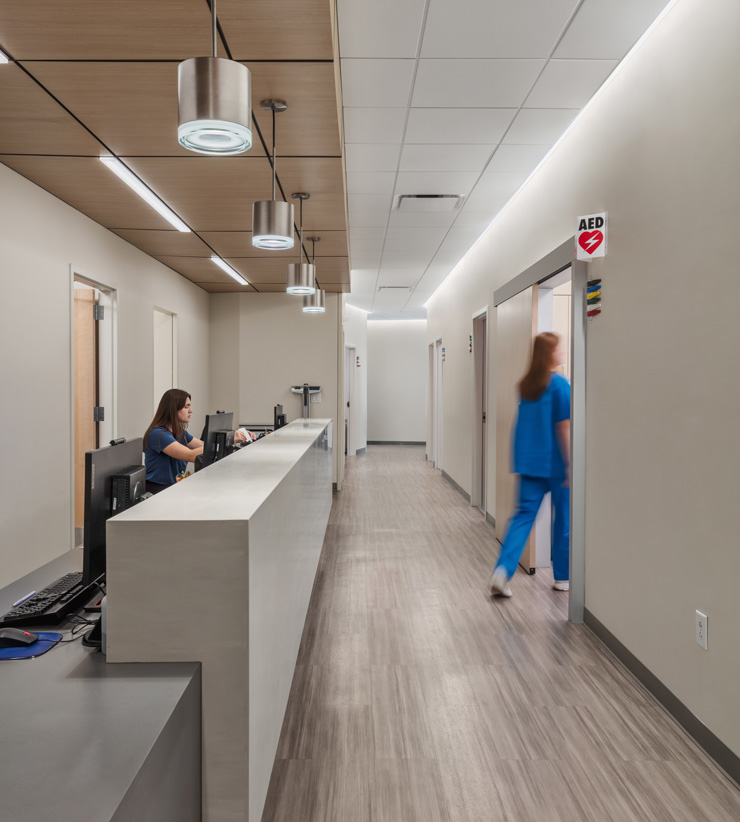 a look down a hallway with patient rooms on the right and admin workspaces on the left