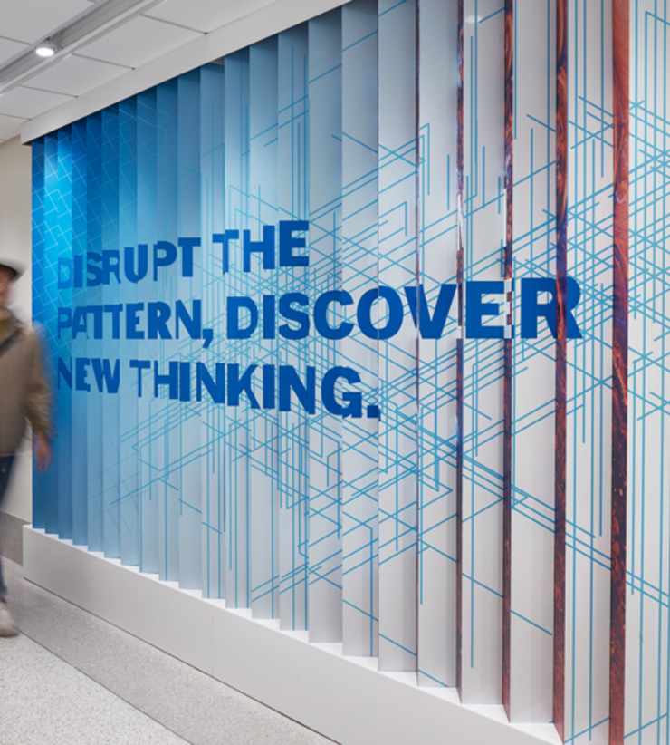 A lenticular wall states, "Disrupt the pattern, discover new thinking."