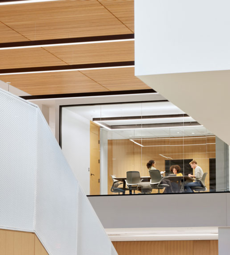 An all-glass conference room is visible in the atrium