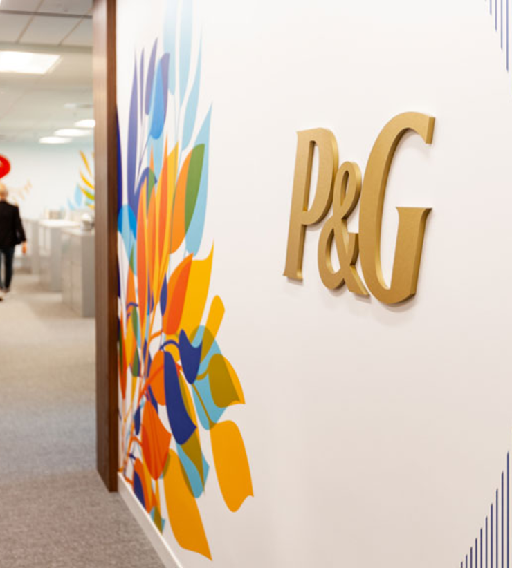 Gold P&G logo appears on wall with bright floral mural at Charlotte office