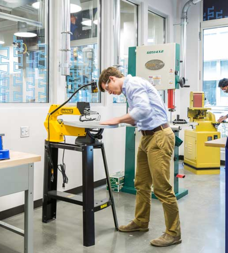 Student uses a saw while in the lab