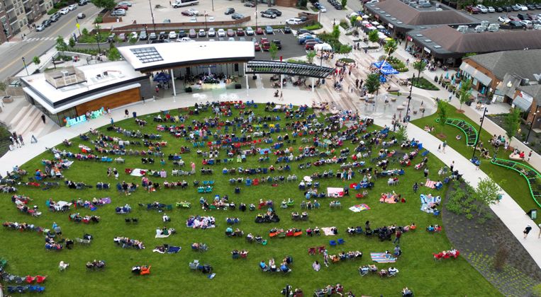 An overhead drone photo of an expansive lawn filled with people