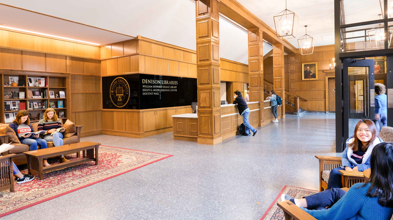 Students sit together inside Denison's Doane Library near the entrance