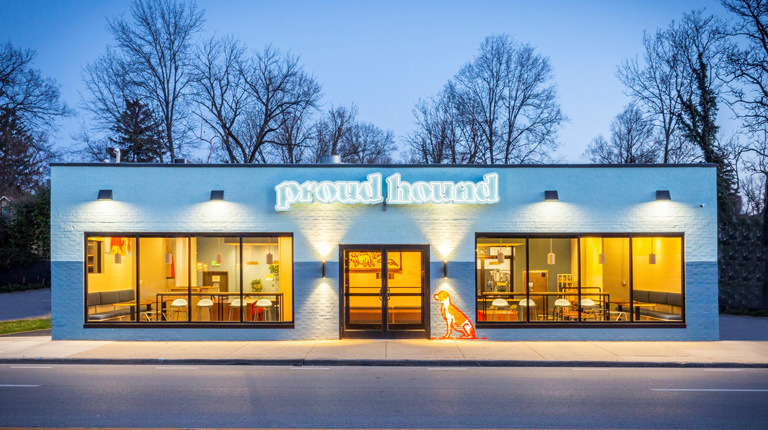 Exterior shot of fully lit Proud Hound store