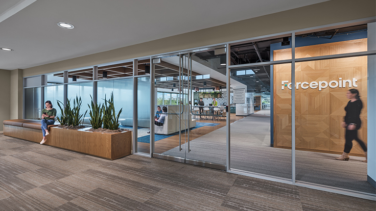 Forcepoint's new entryway is clean and modern, lined with windows that give employees, clients, and passerbys alike a look into the headquarters. Its logo stands out on a wood backdrop indicating who the company is.