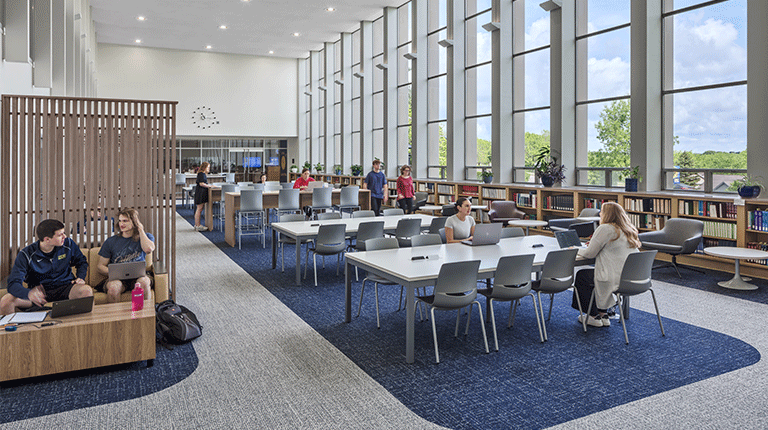 Users enjoying the Alter Library at Mount St. Joseph University, with large windows flooding the space with natural light.