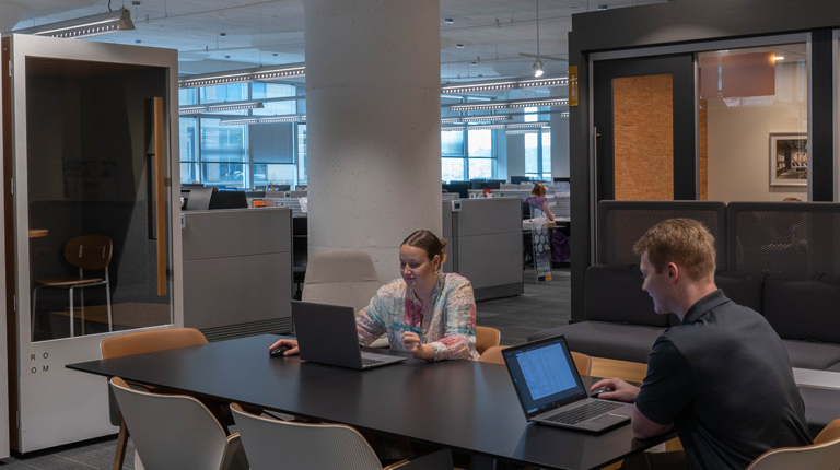 BHDP employees collaborate together at a table near the kitchen