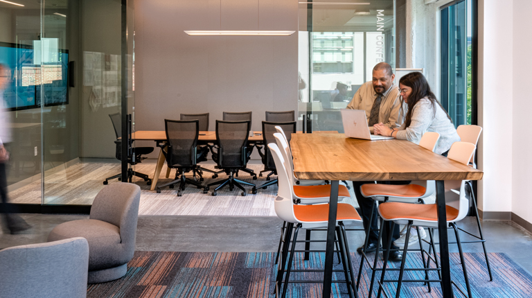 Employees work together at a high-top table in BHDP's Raleigh office
